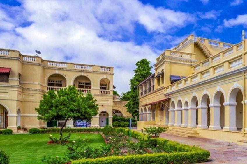 A courtyard with a building featuring arched windows and a central tree. 5