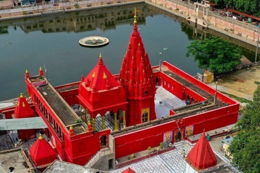 A red temple complex with a central spire, surrounded by water. 1