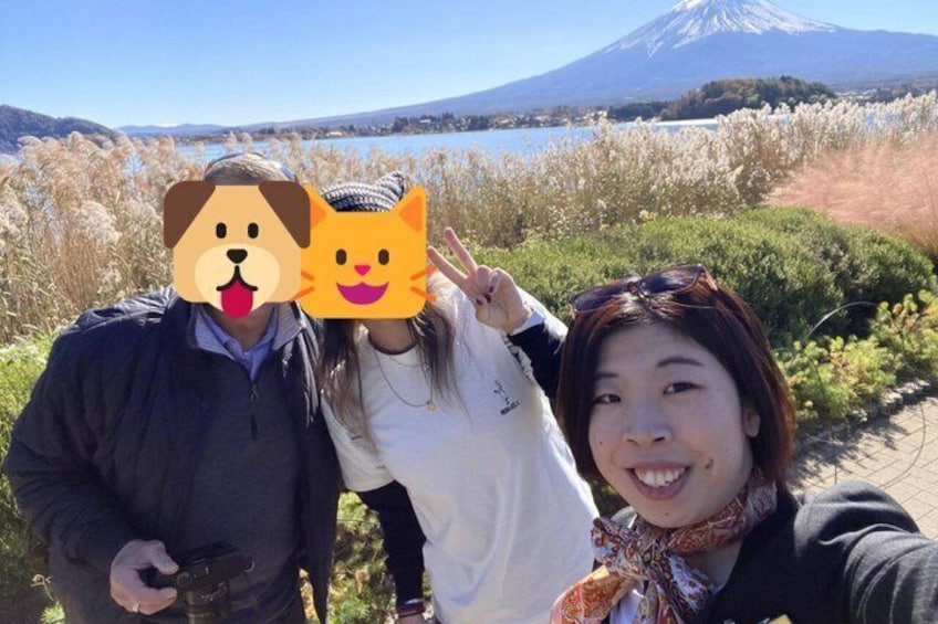 Tres personas con una montaña y un lago al fondo. 3
