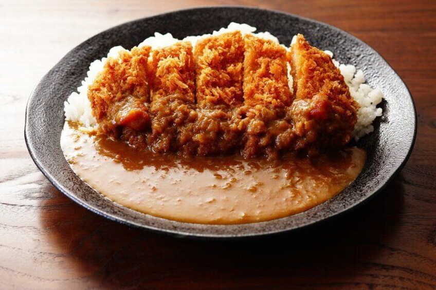 A plate of Tonkatsu with rice and sauce. 5