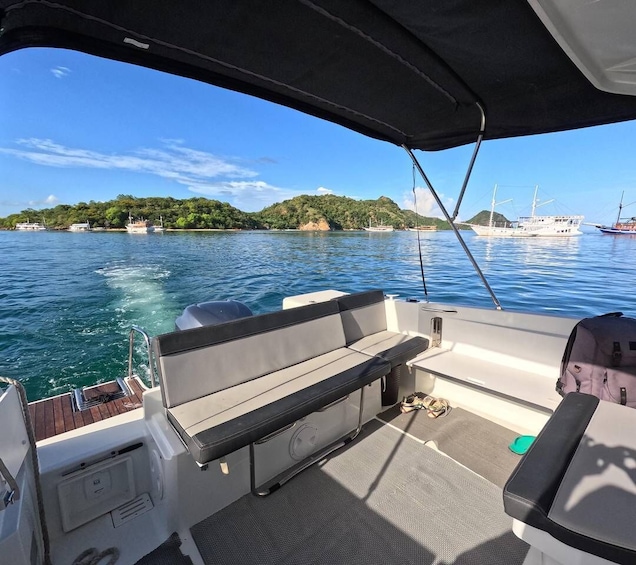 A boat deck with seating, a wakeboard, and a wakeboard cable. 1