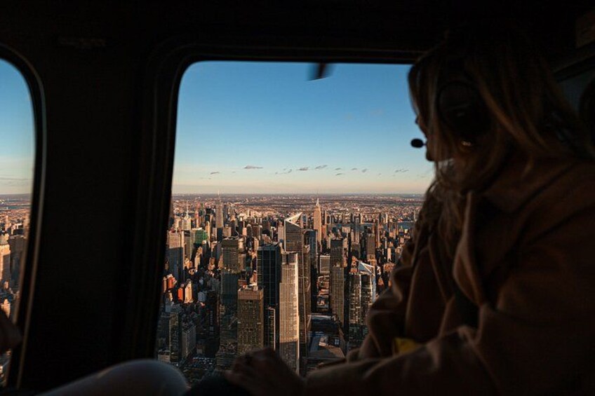 A cityscape viewed from a vehicle, with a person in the foreground. 3