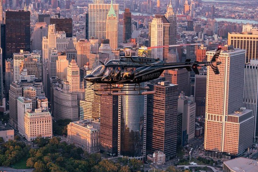 A helicopter flying over a cityscape with tall buildings. 3