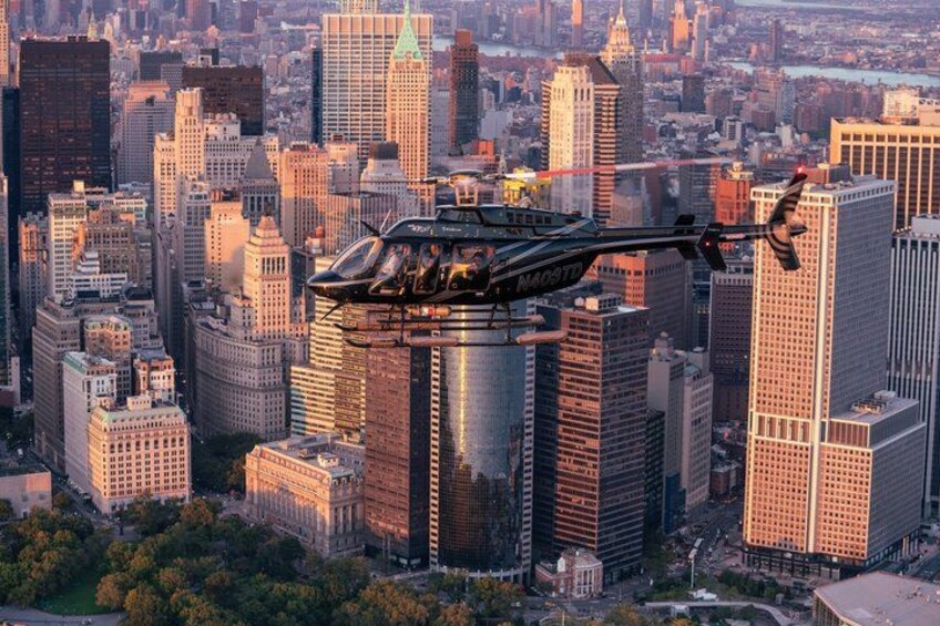 Un helicóptero volando sobre un paisaje urbano con edificios altos. 3