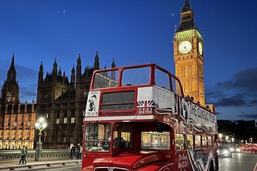 A red double-decker bus with 'The Classic Tour' written on it, driving past the Big Ben clock tower. 3
