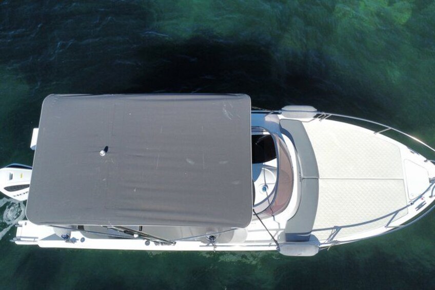 Una barca bianca con una cabina e un ponte coperto, che galleggia in acque limpide. 2