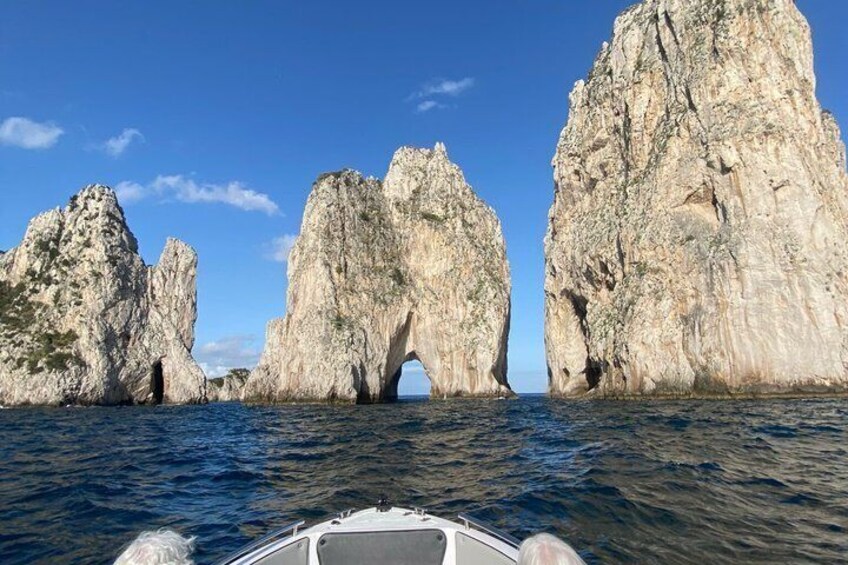 Un barco navegando por una estrecha vía fluvial bordeada por grandes formaciones rocosas. 1