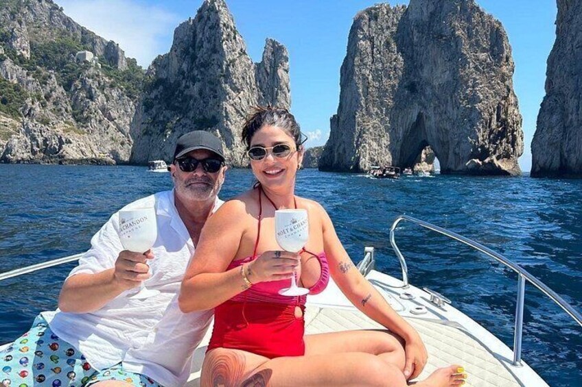 Dos personas en un bote con acantilados rocosos al fondo. 2