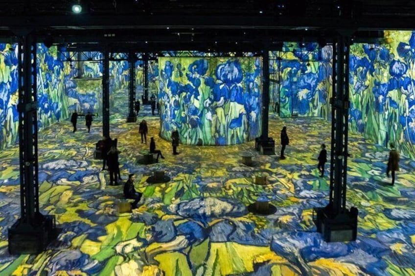 Un'installazione artistica con pavimento e pareti ricoperte da motivi blu e gialli, e diverse persone che vi passeggiano. 4
