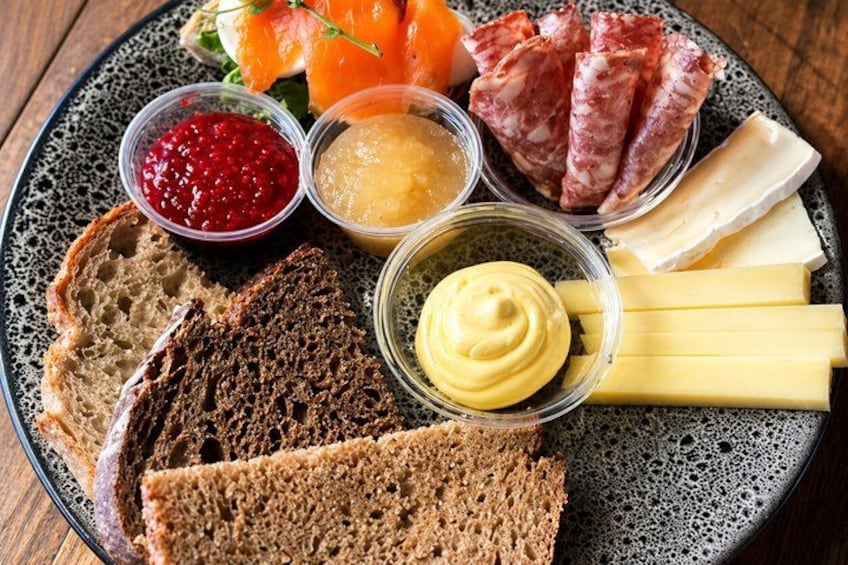 Une assiette contenant divers aliments, notamment du pain, du fromage et de la viande. 1