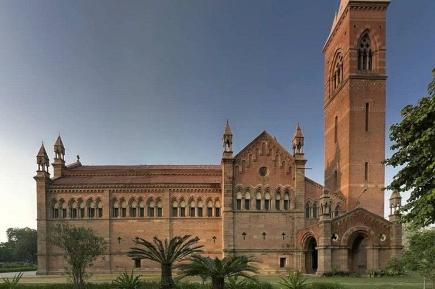 A large brick building with a prominent tower and arched windows. 5