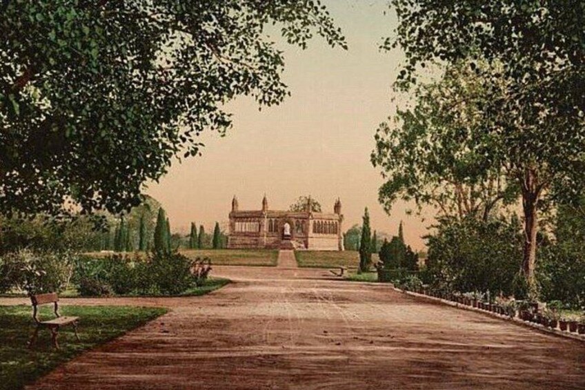 A large, symmetrical building with a central entrance, surrounded by well-maintained gardens and trees. 4
