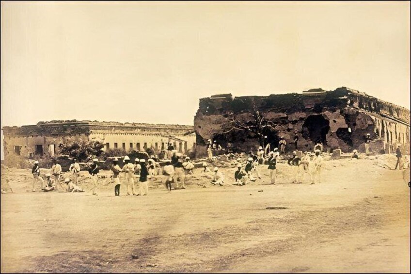 A historical site with ancient ruins and a crowd of people. 2