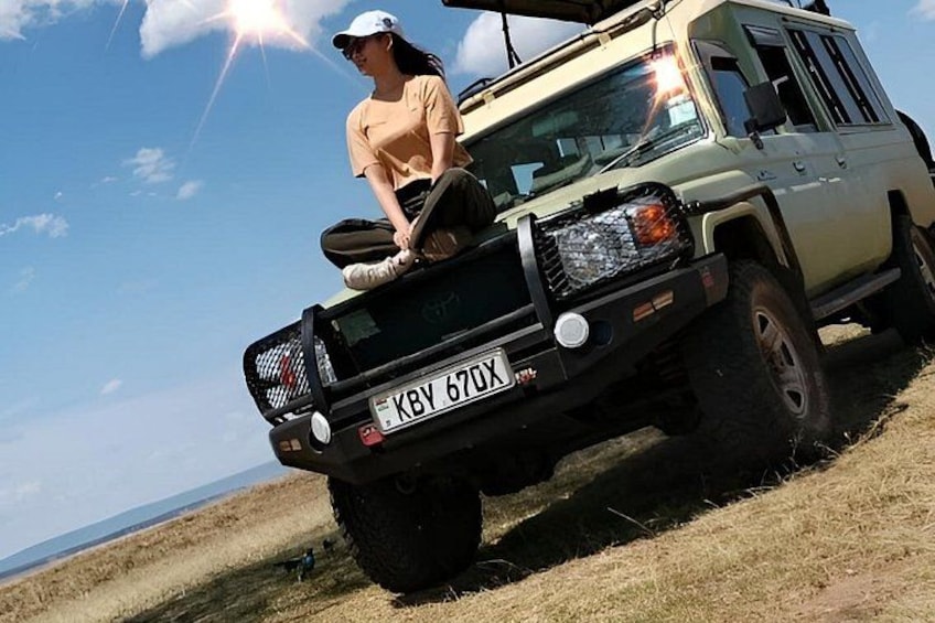 A person sitting on the back of a vehicle with a license plate reading 'KBY 670X'. 2