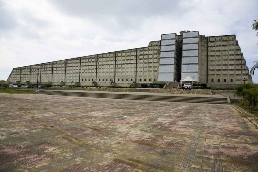 A large, rectangular building with a flat roof and a series of windows. 1