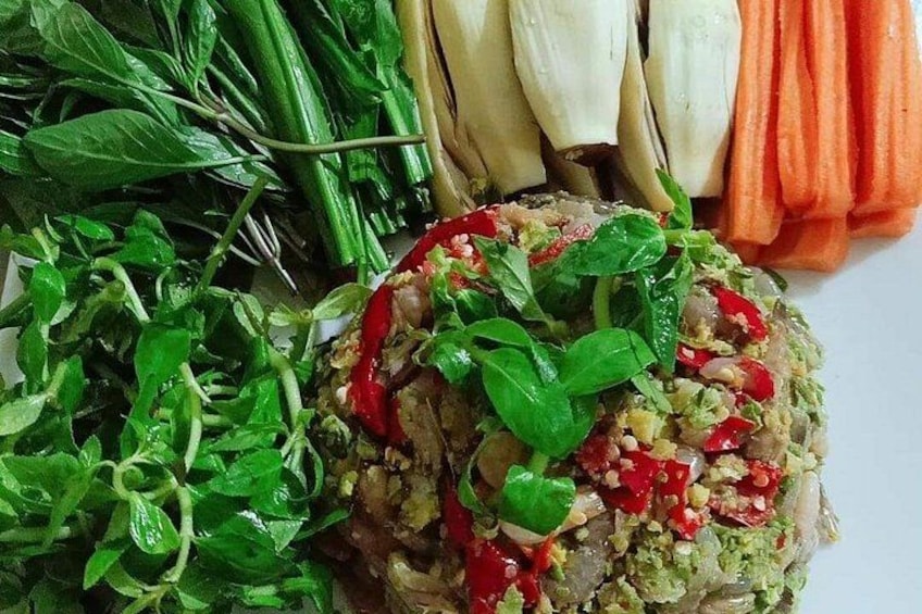 Un plato de comida con una variedad de verduras y una porción de arroz coronada con hierbas y pimientos rojos. 4