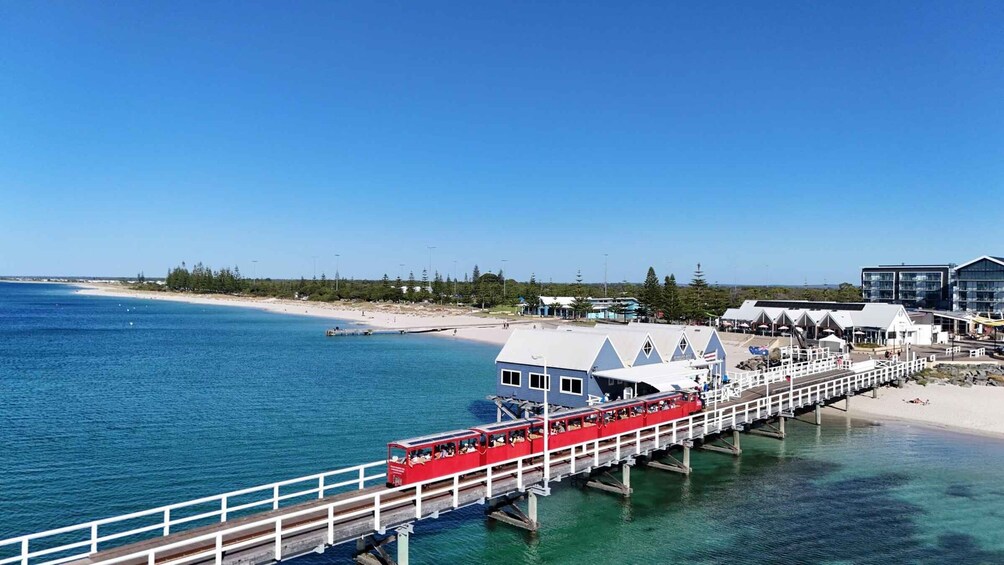 A red ferry on a pier, a beach, and a clear blue sky. 3