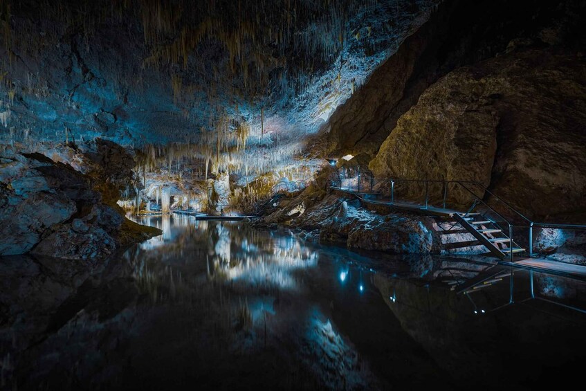 A cave with stalactites, a water pool, and a staircase. 5