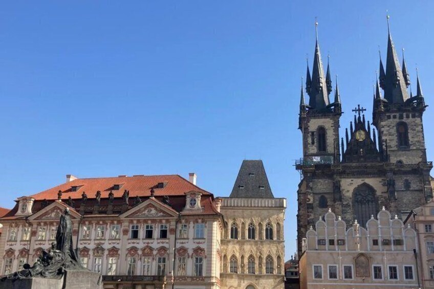 A historic building with a red roof and a Gothic church with two towers. 2