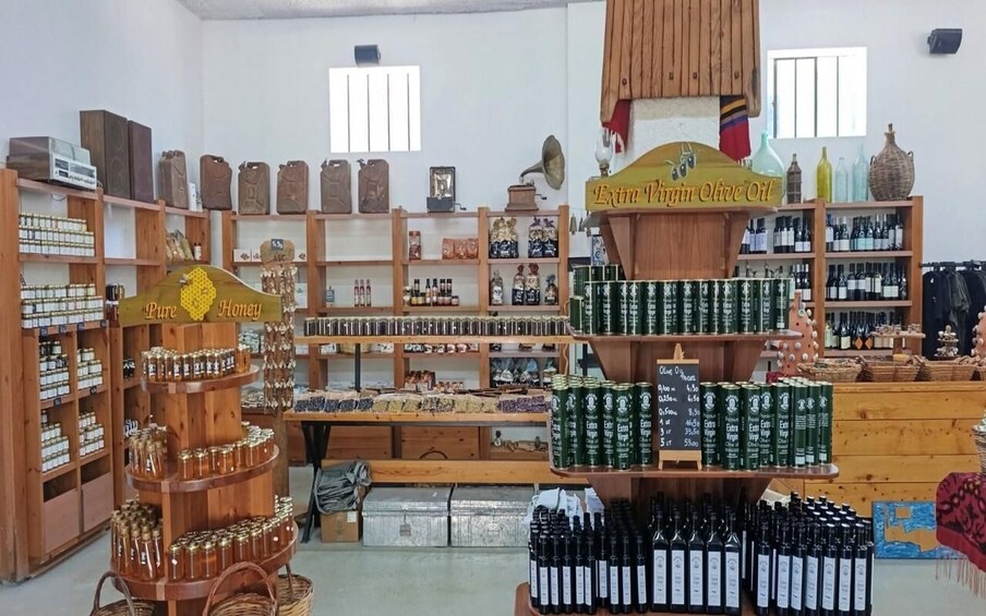 A store with shelves of honey, olive oil, and wine bottles. 3