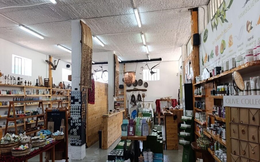 A boutique with wooden shelves, a variety of products, and a sign reading 'OLIVE COLLECT'. 2