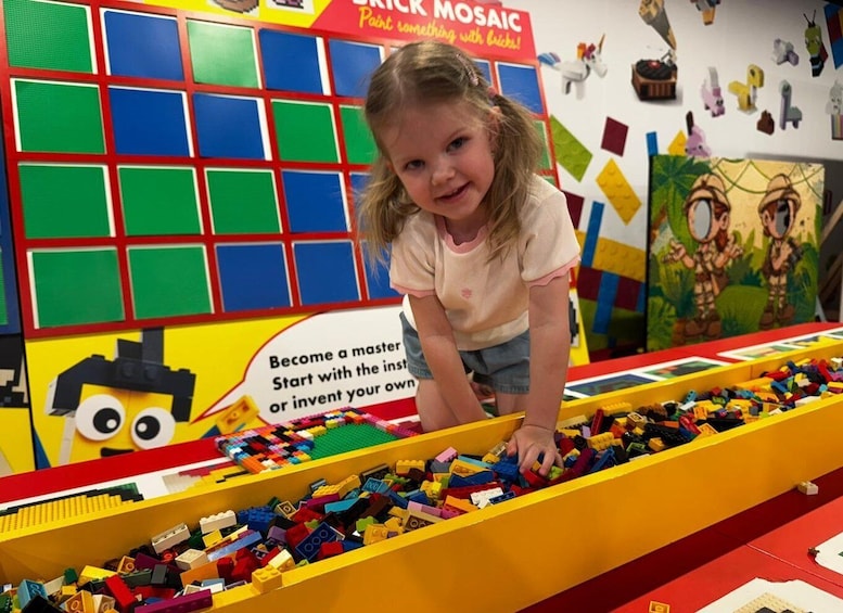 A child playing with a large collection of colorful building blocks in a play area. 3