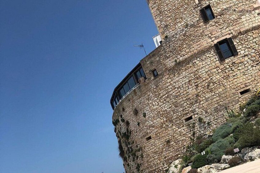 A stone tower with a balcony and a clear blue sky. 4