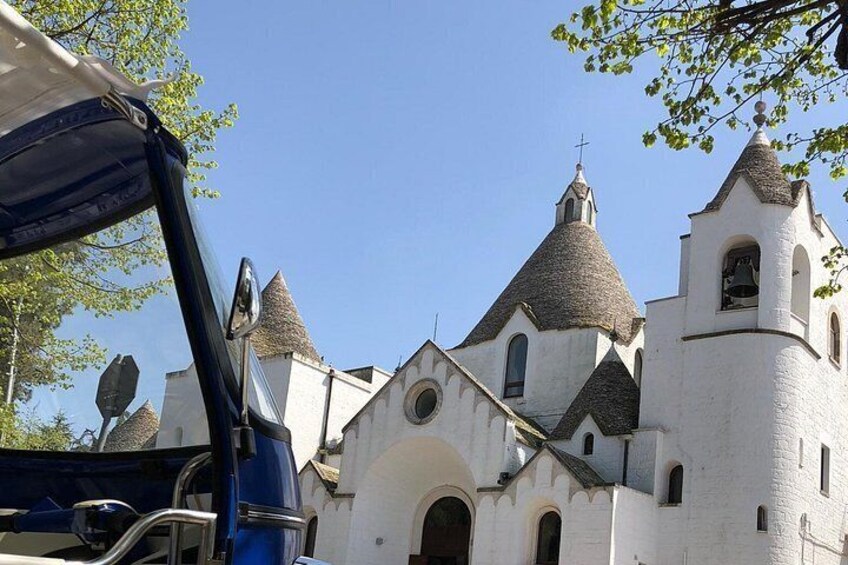 A white church with multiple pointed towers and a bell tower. 2