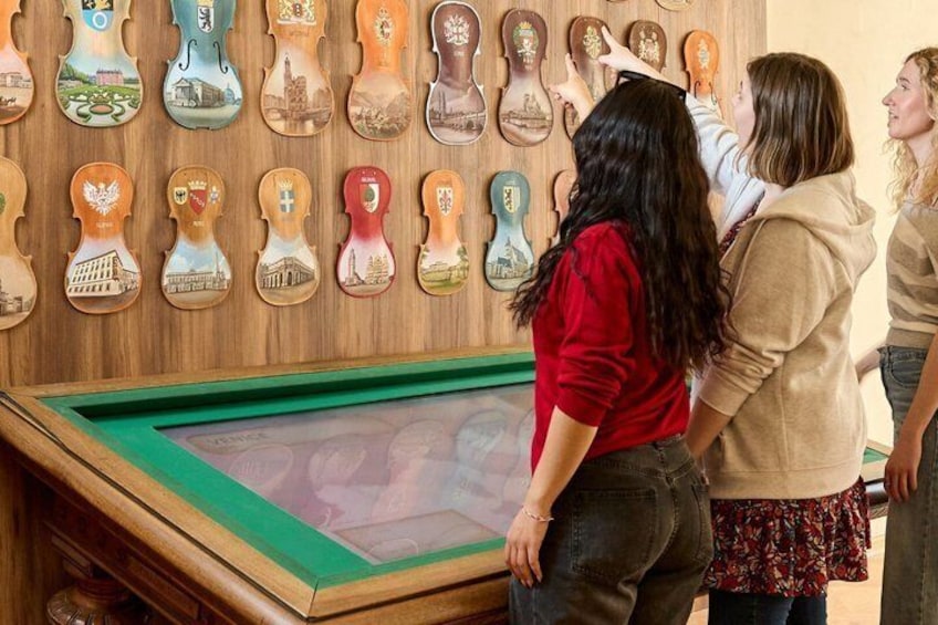 A display of wooden plaques with various designs, a framed photograph, and a green mat on the floor. 5