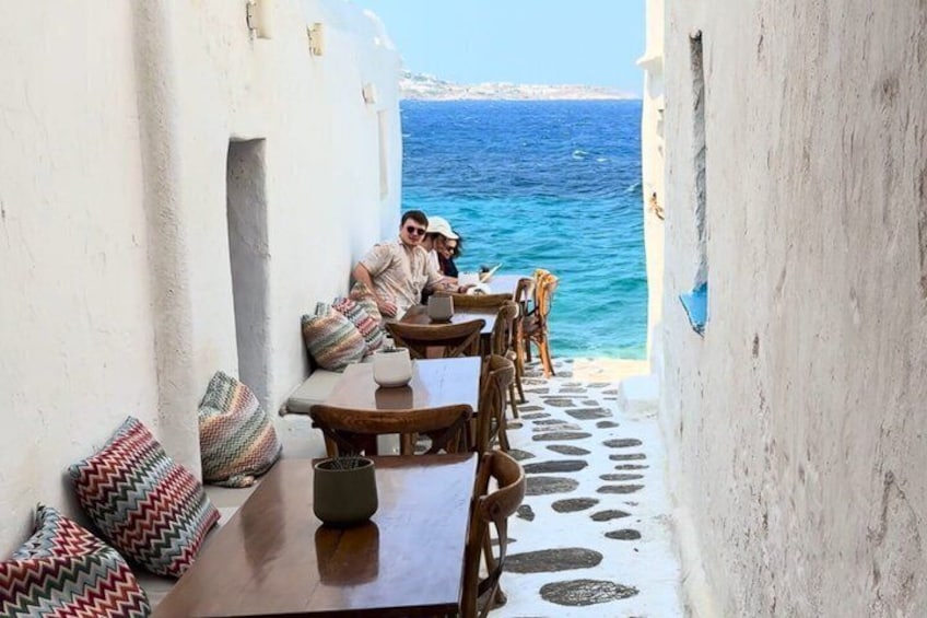 Una piccola area esterna con tavoli e sedie, affacciata sul mare. 1