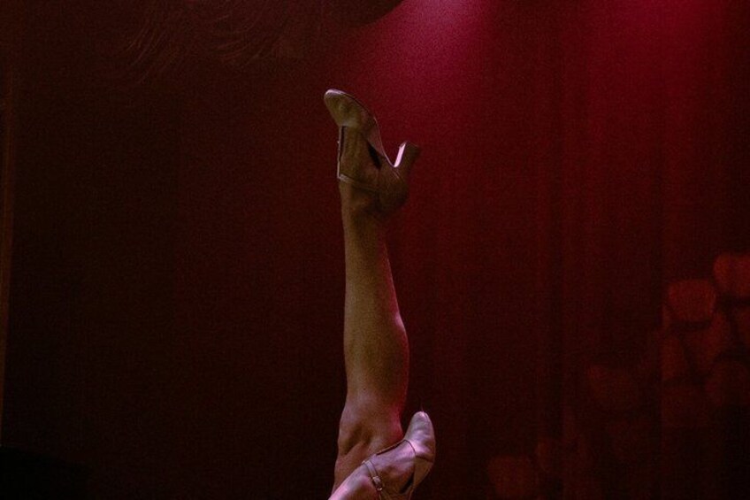 A person performing a handstand against a red background. 2