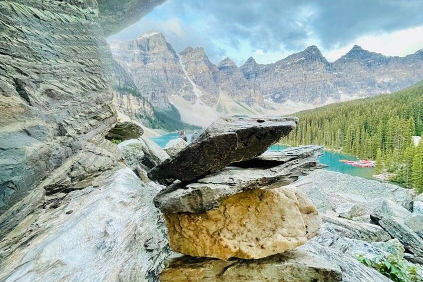 Ein felsiges Gelände mit freiem Blick auf ein Gebirge und einen See. 3