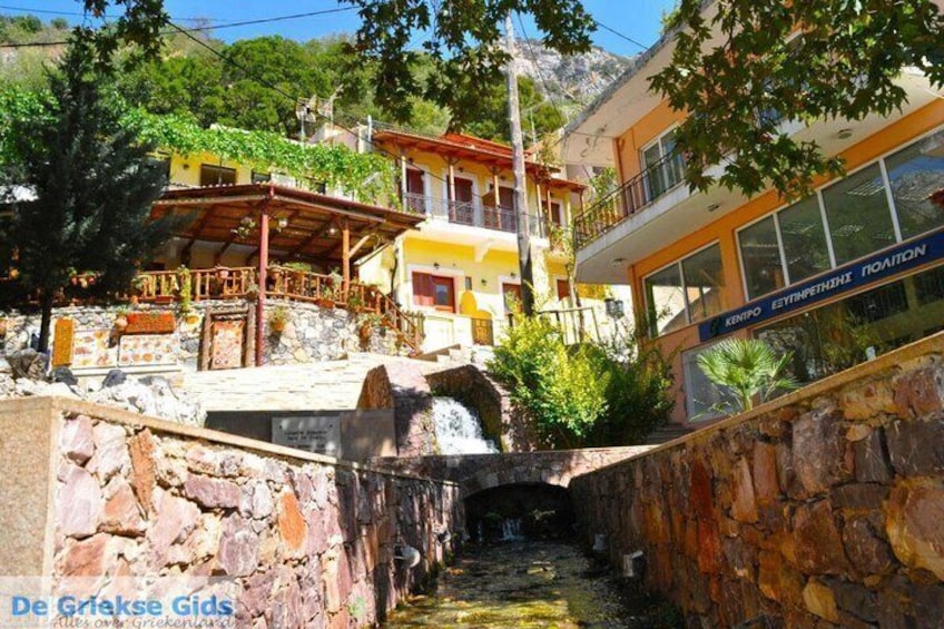A stone bridge, a yellow building, and a sign for 'KEMPO ESTHETIKON POION'. 4