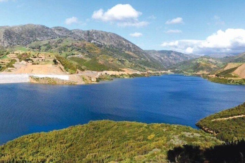 A lake surrounded by mountains and greenery. 2
