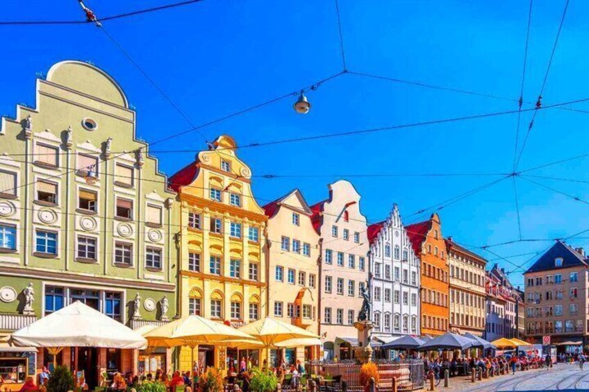 A street with colorful buildings and a tram line. 4