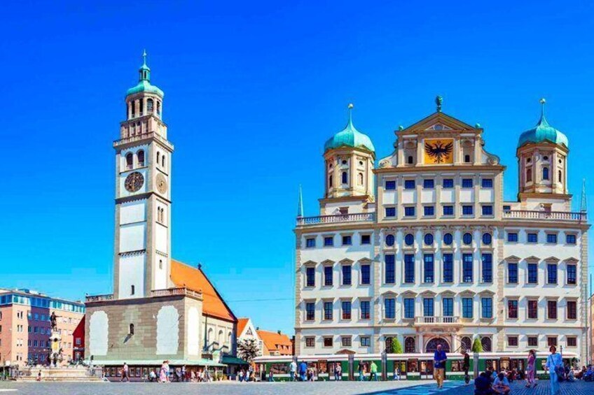 A historic building with a clock tower and two domed structures. 5