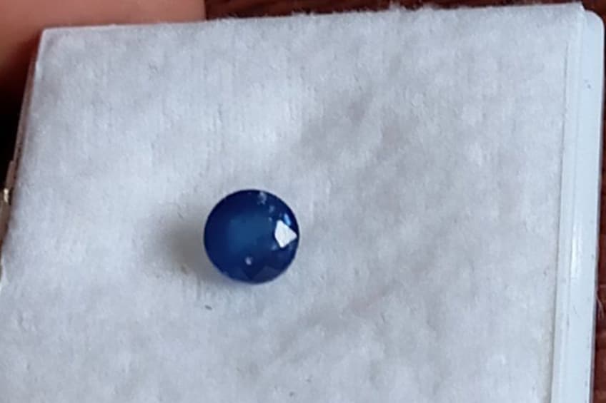 Een blauwe edelsteen in een witte, geribbelde doos. 5