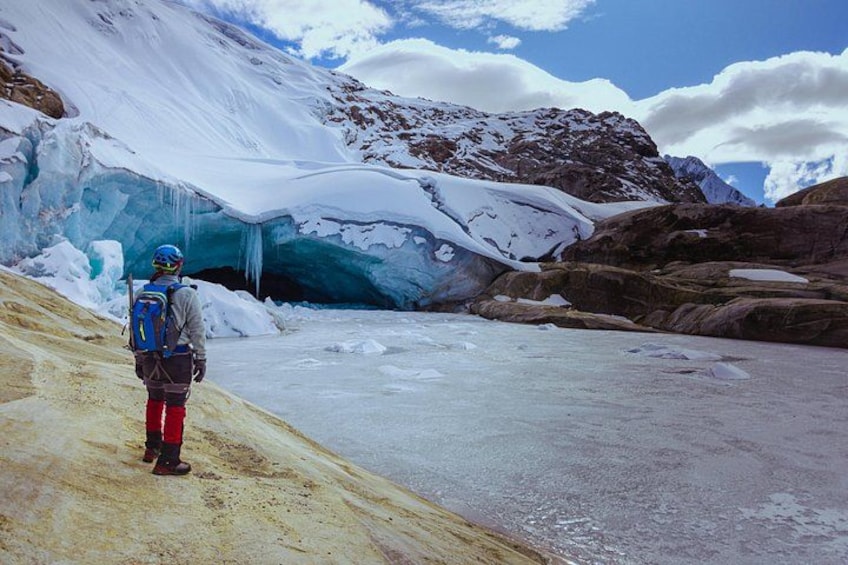 A person standing on a snow-covered slope with a glacier in the background. 2