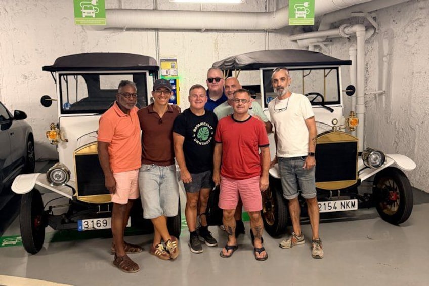 Een groep mensen staat voor een oldtimer met kenteken 3159. 5