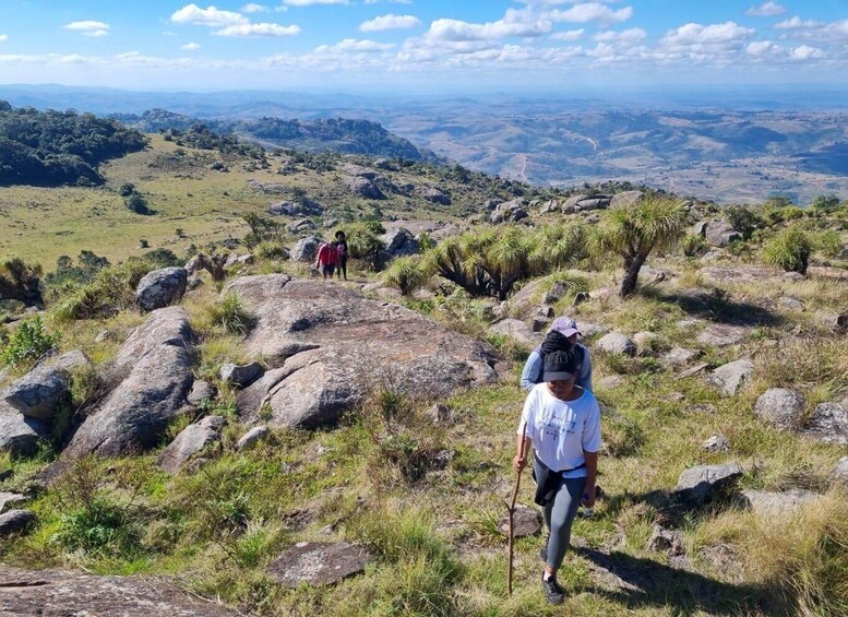 A hiker on a rocky trail with a mountainous landscape in the background. 5