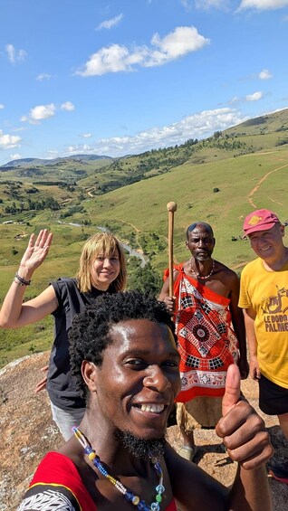 A group of people on a grassy hill with a river in the background. 1