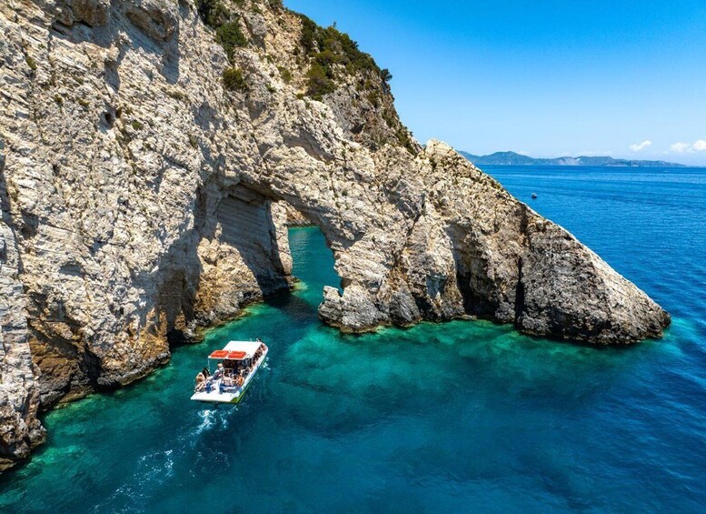 A boat navigating through a rocky coastal passage with clear turquoise waters. 4