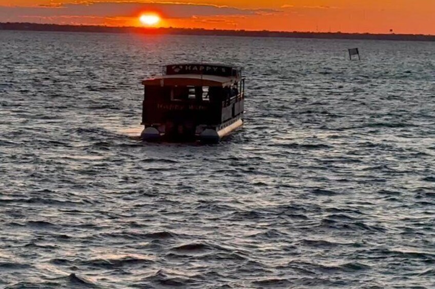 A boat named 'HAPPY' on the water during sunset. 2