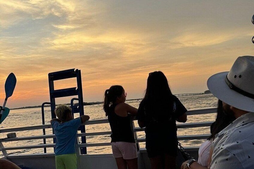 Atardecer sobre el agua con gente en un bote. 4