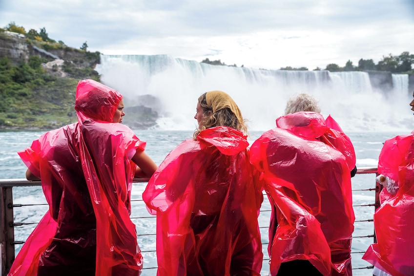 A group of people in red rain ponchos looking at a waterfall. 5