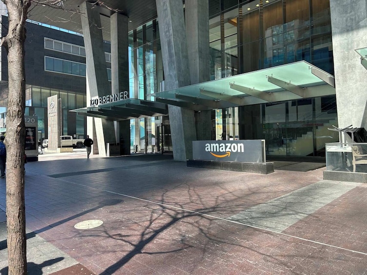 A modern building with a glass facade, a sign for 'amazon,' and a 'BREMNER' sign above the entrance. 2