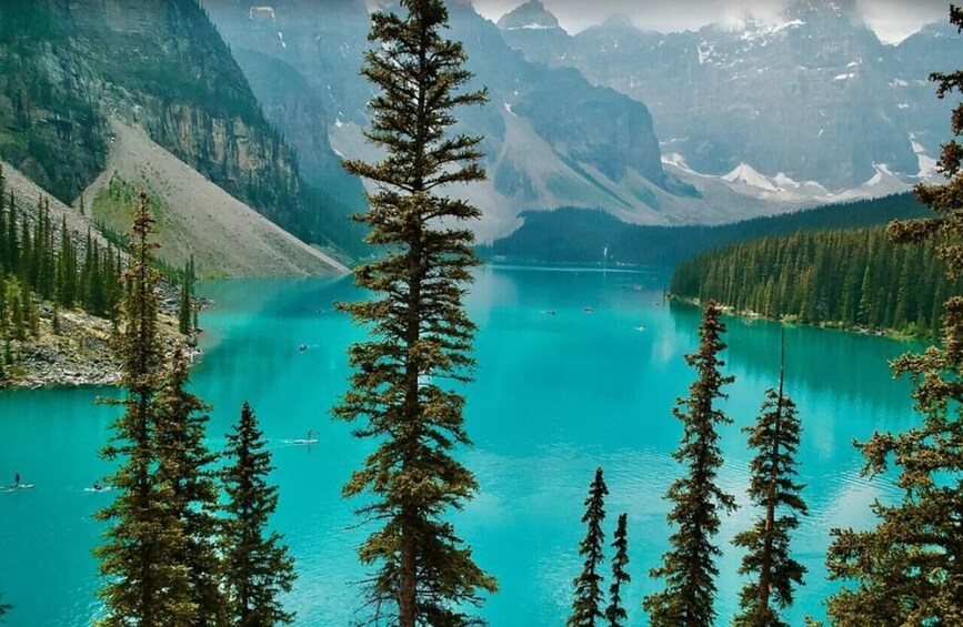 A turquoise lake surrounded by mountains and dense forests. 4