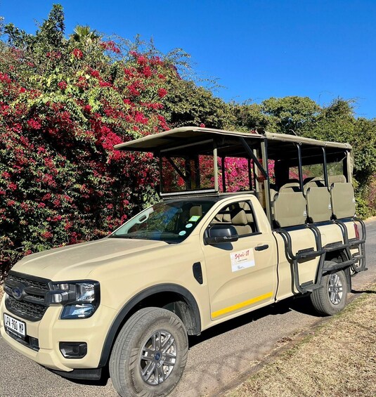 A beige off-road vehicle with a roof rack and a spare tire mounted on the back. 3