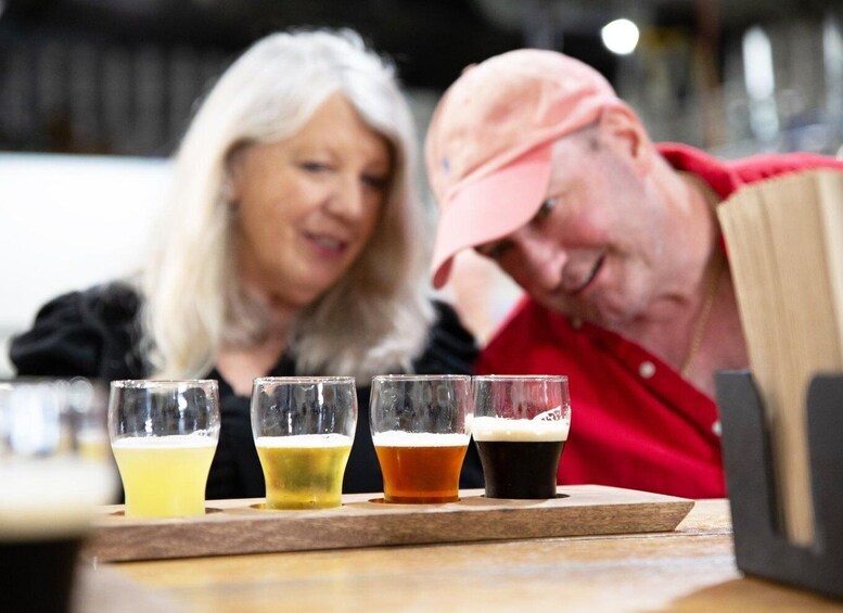 Four glasses of beer on a wooden tray. 1