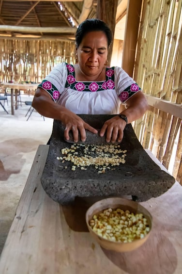 A person using a stone mortar and pestle to grind nuts. 1